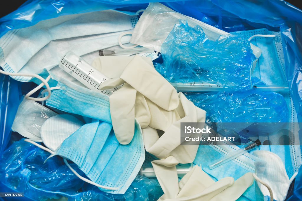 Klinikabfaelle Medical trash. Coronavirus protection equipment in medical waste bin. Used face masks and sterile gloves. Doctor uniform for patient treatment in hospital. Prevention the spread of COVID-19.